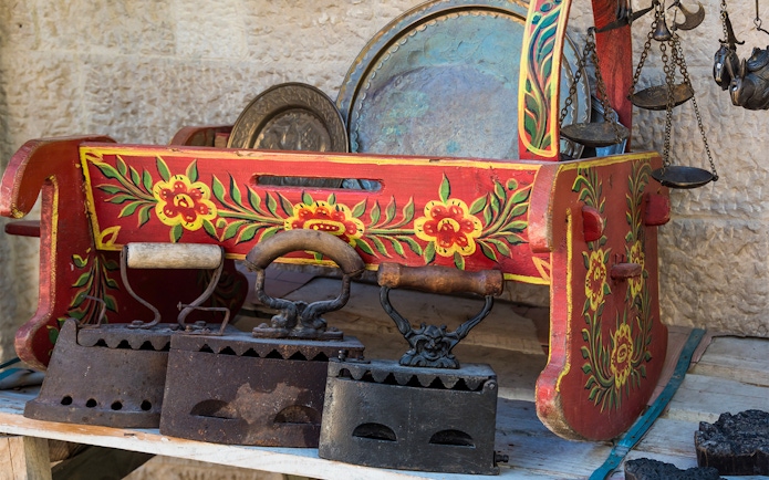 Antique irons and painted wooden box at Kruje Albania Old Market.