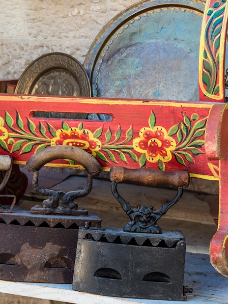 Antique irons and painted wooden box at Kruje Albania Old Market.