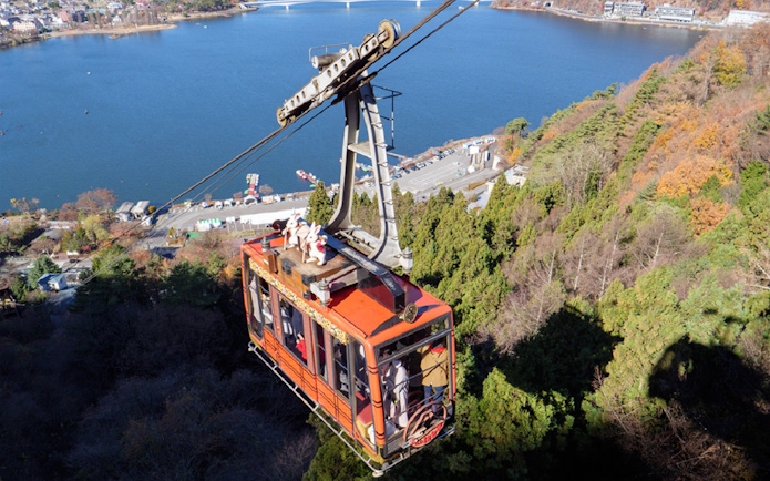 Kawaguchiko Mt. Fuji Panoramic Ropeway cable car ascending over Lake Kawaguchi.