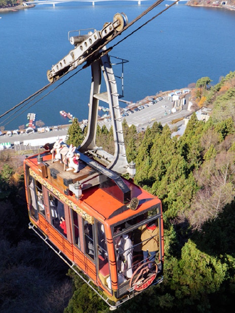 Kawaguchiko Mt. Fuji Panoramic Ropeway cable car ascending over Lake Kawaguchi.