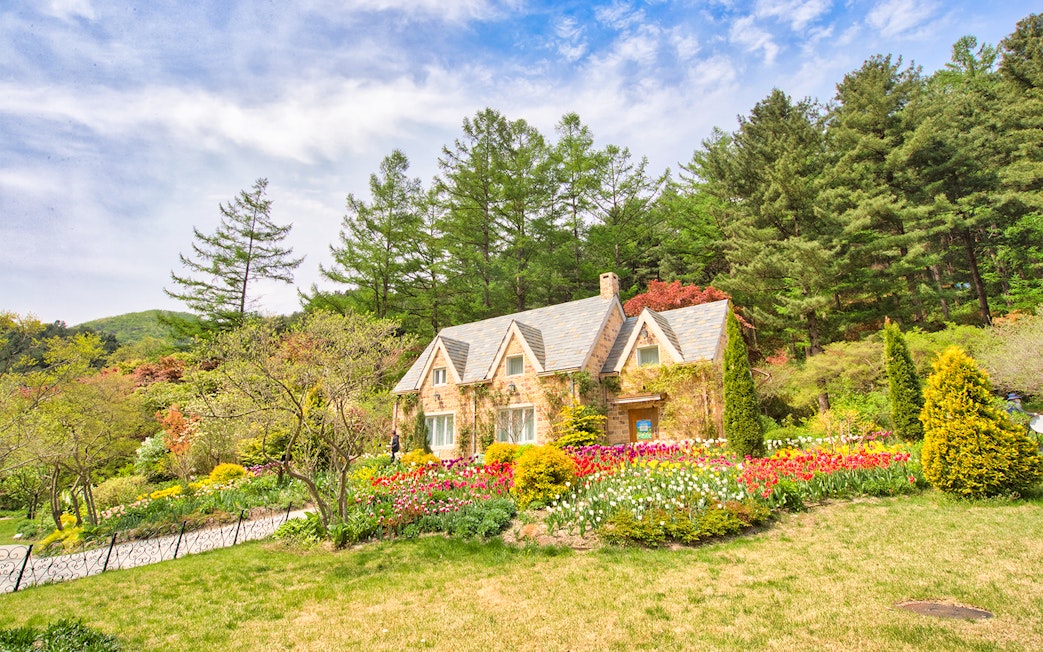 Stone cottage with tulip gardens and trees near Gapyeong, South Korea.