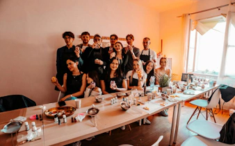 Group enjoying candle-making workshop in Krakow studio with fragrances, wine, and music.