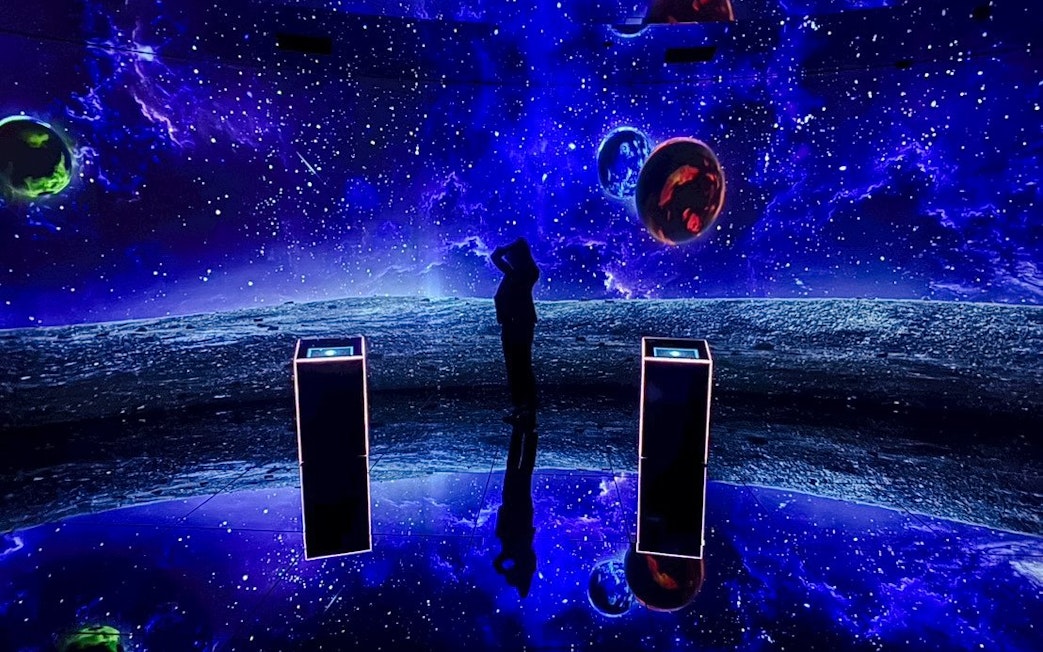 Tourist exploring space-themed exhibit at MIRACLEWORLD Osaka.