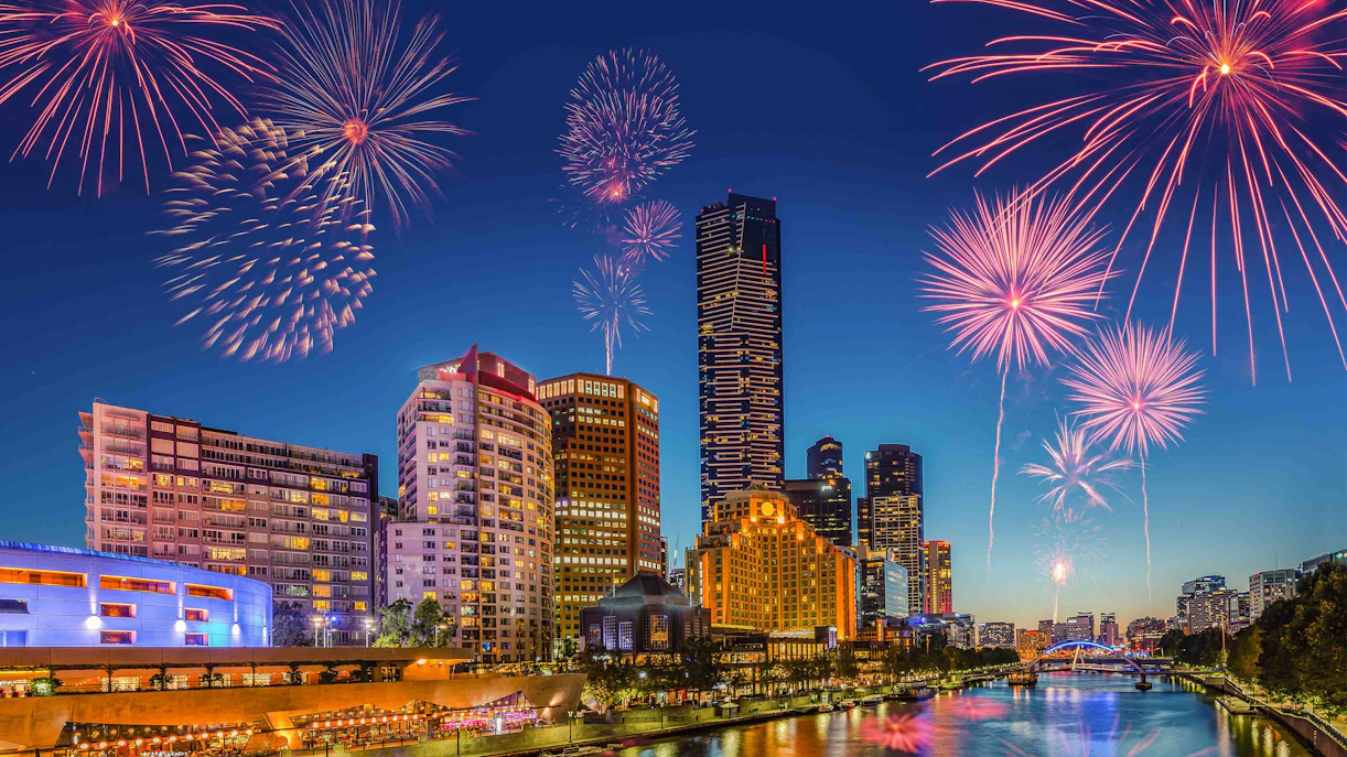 Fireworks over Melbourne skyline viewed from a rooftop bar on New Year's Eve.