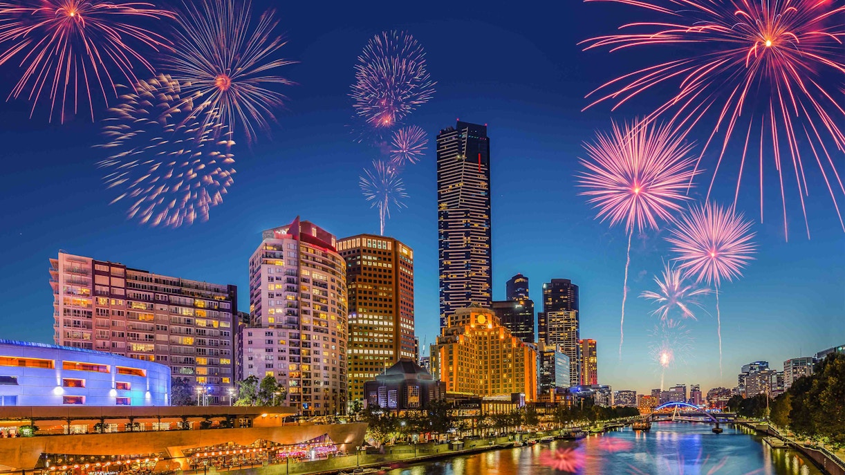 Fireworks over Melbourne skyline viewed from a rooftop bar on New Year's Eve.