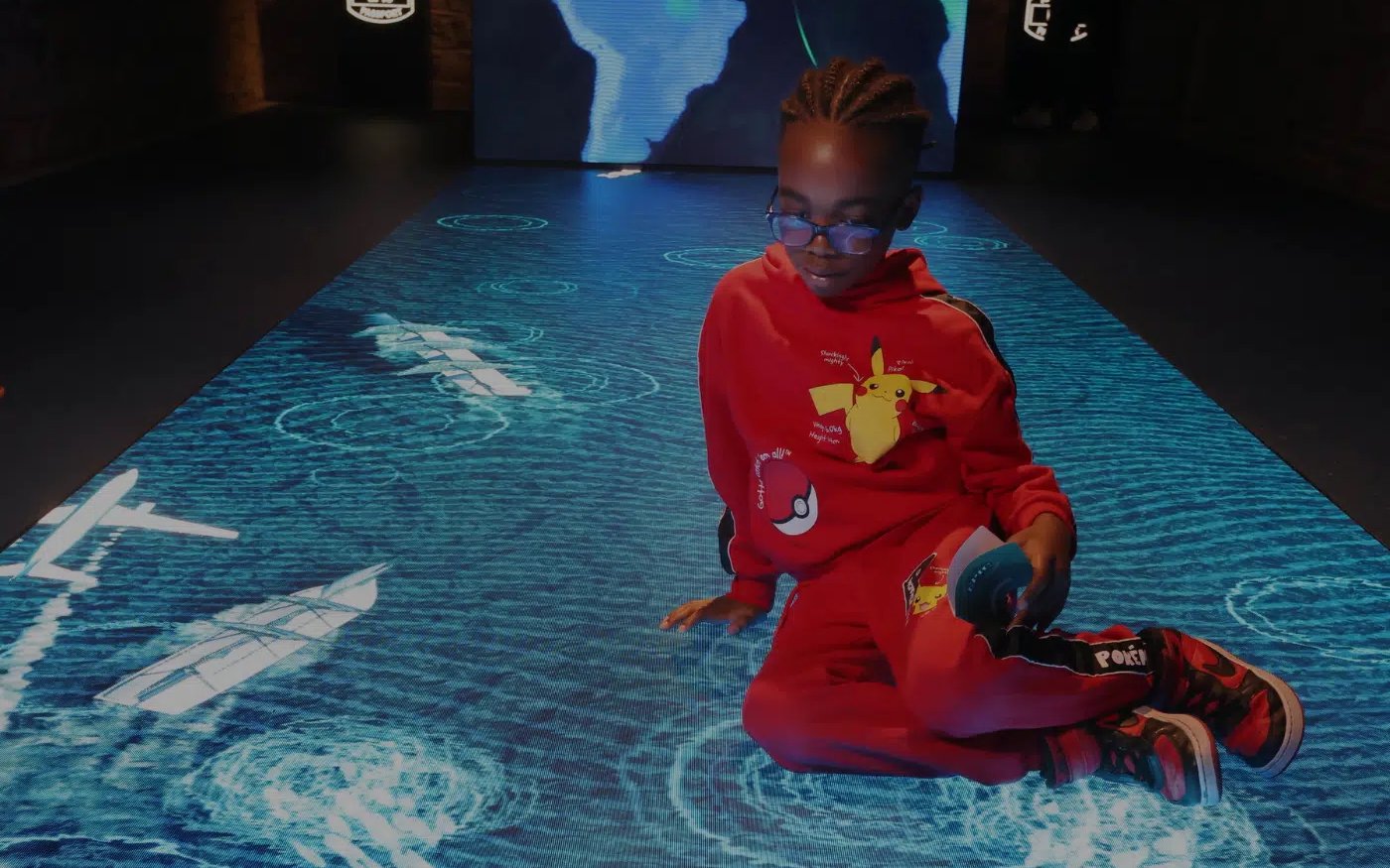 Child interacting with digital floor display at Epic Museum.