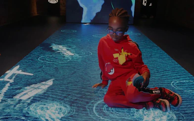 Child interacting with digital floor display at Epic Museum.