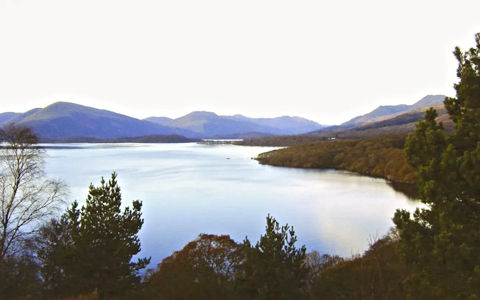 Loch Lomond with surrounding hills and trees in Scotland.