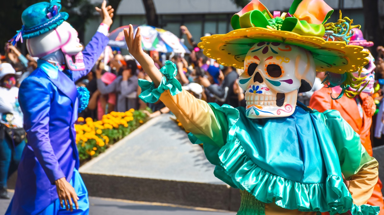 Day of the Dead parade in Mexico City with colorful costumes and traditional skull masks.