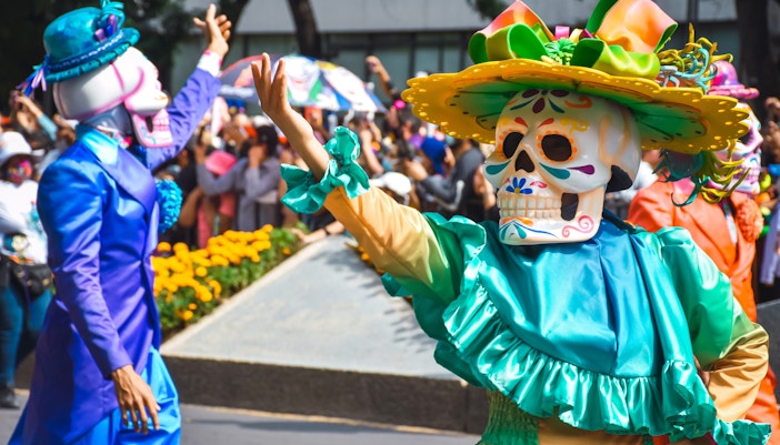 Day of the Dead parade in Mexico City with colorful costumes and traditional skull masks.