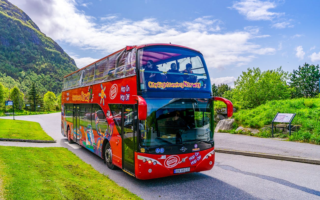 Alesund hop-on hop-off bus on scenic route with mountains in Norway.