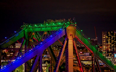 Climbers on illuminated Story Bridge at night in Brisbane, Australia.