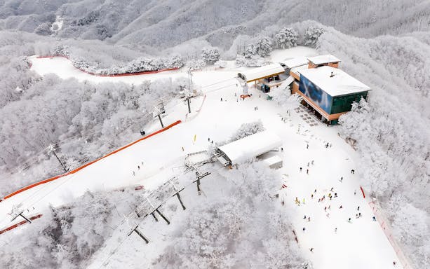Aerial view of Vivaldi Park Snowy Land with skiers and snow-covered trees.