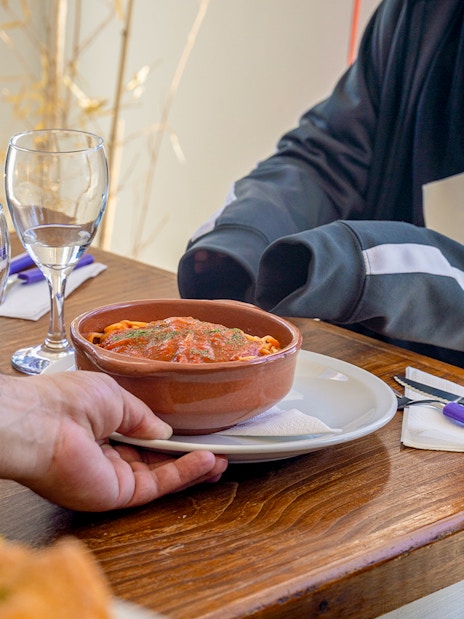 Tourist enjoying lunch with pasta dish during Full-Day Tour to El Chaltén.