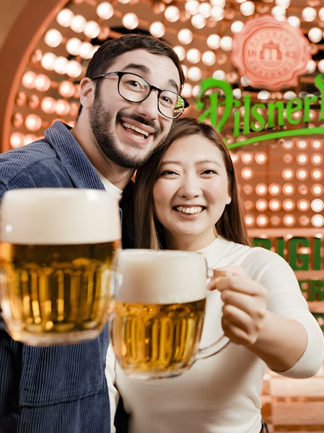 Tourists enjoying beer at Pilsner Urquell Experience in Prague.