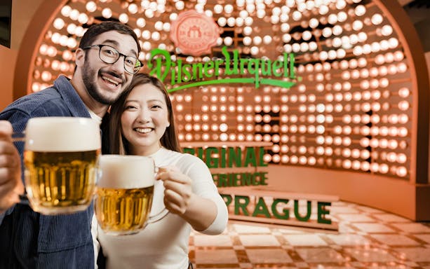 Tourists enjoying beer at Pilsner Urquell Experience in Prague.