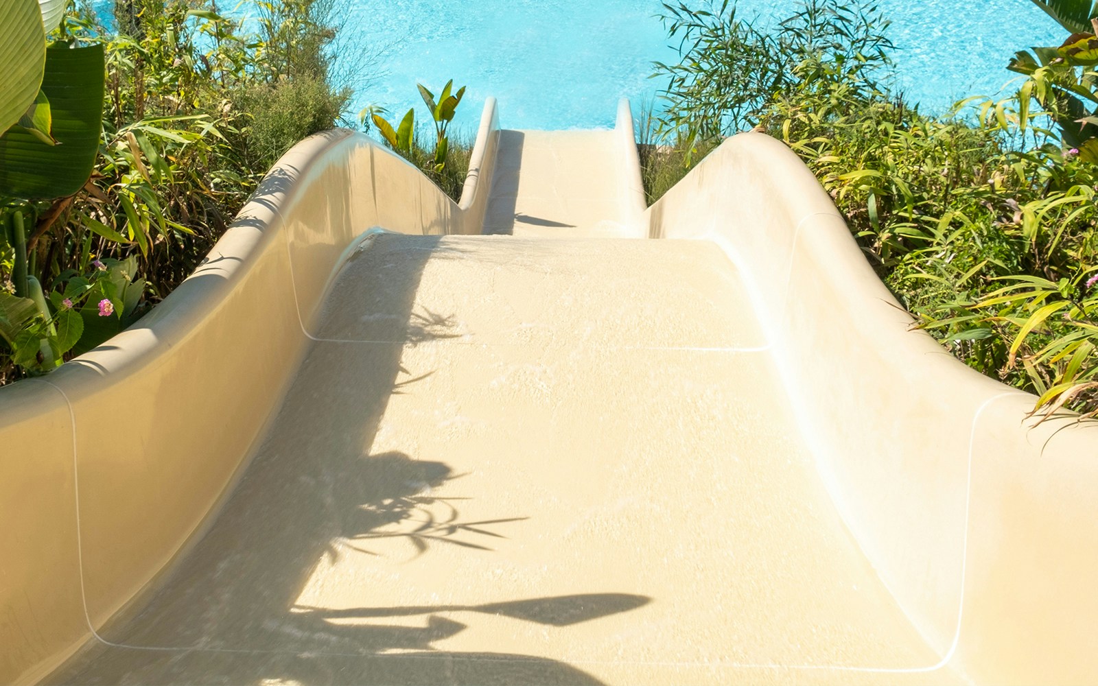 Captain Space Maker slide at Caribe Bay water park surrounded by lush greenery.