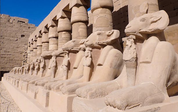 Row of ancient ram-headed sphinx statues at Karnak Temple, Luxor, Egypt.