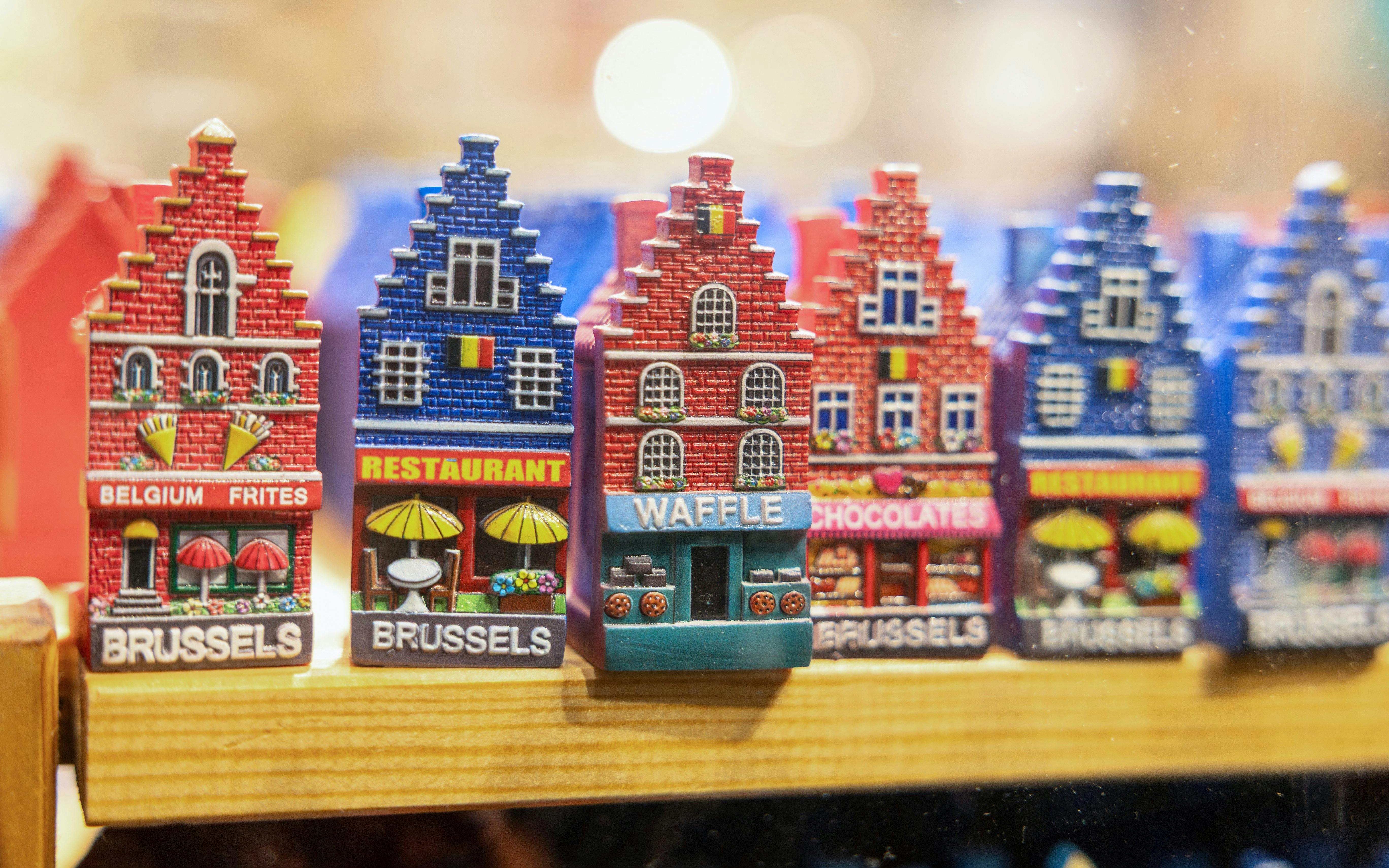 Brussels souvenir magnets featuring colorful miniature buildings with local themes.