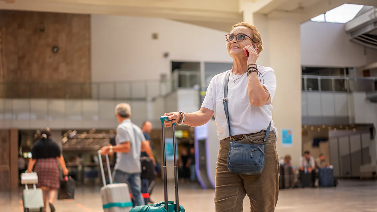 Traveler with luggage at airport terminal.