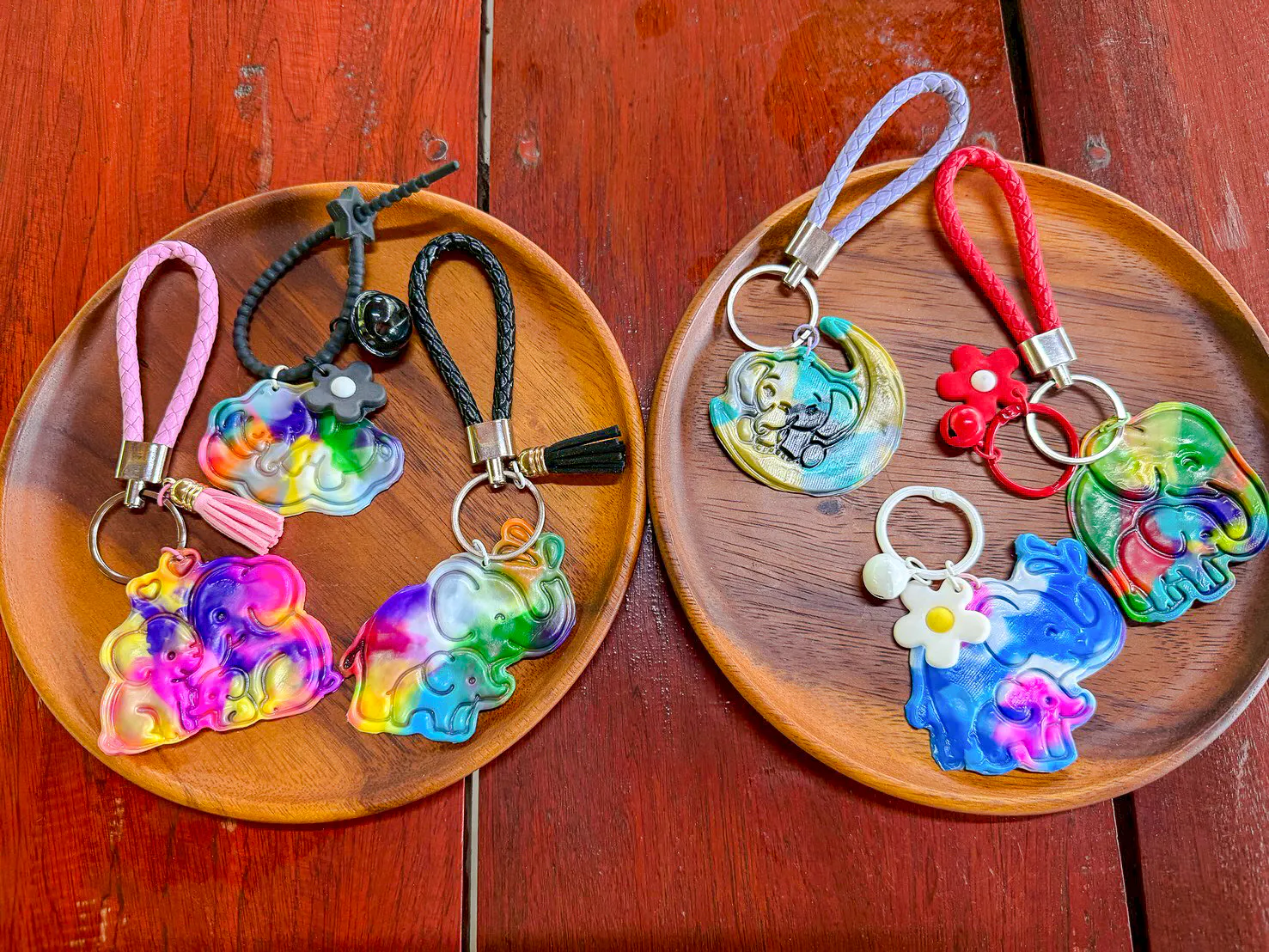 Colorful elephant keychains on wooden plates at Krabi Elephant Local Project workshop.