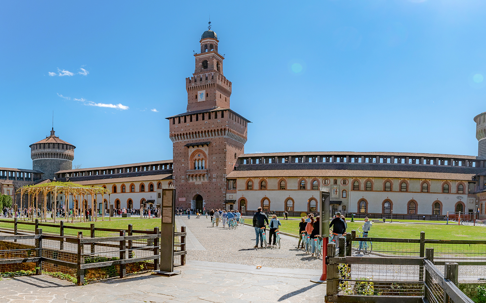 Courtyard of Sforza Castle in Milan with tourists and historic architecture.