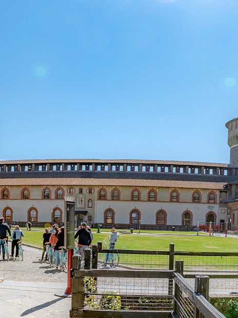 Courtyard of Sforza Castle in Milan with tourists and historic architecture.