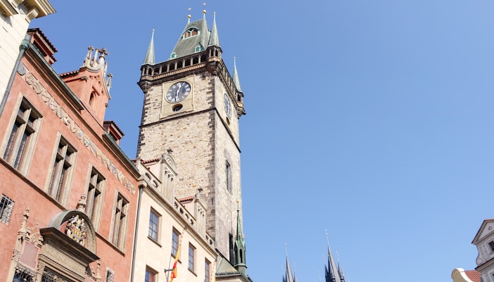 Old Town Hall Tower in Prague with clock and Gothic architecture against blue sky.