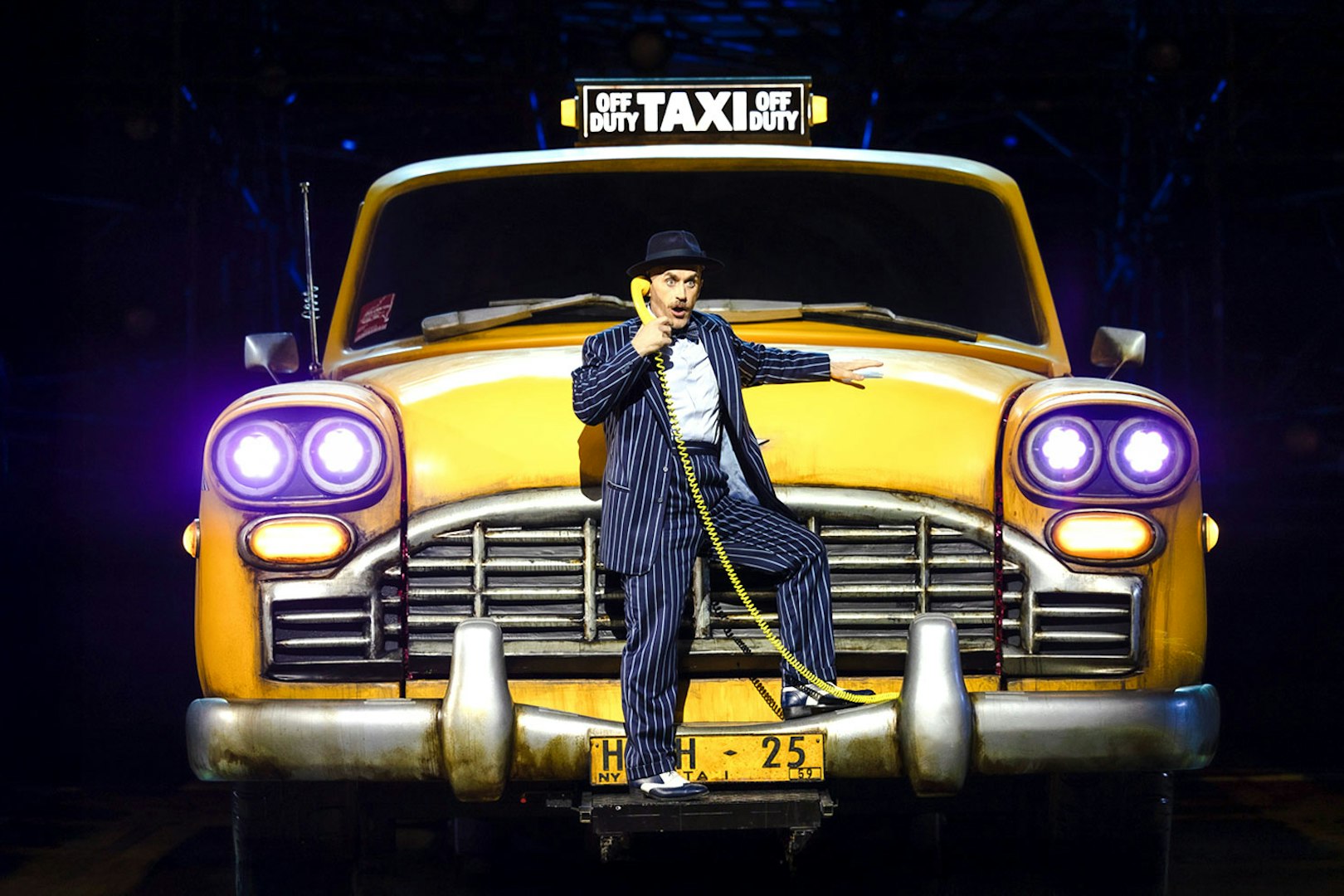 Performer in front of a yellow taxi during Guys & Dolls on Sydney Harbour.