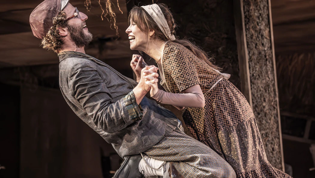 Actors performing a joyful scene in "Fiddler on the Roof" musical.