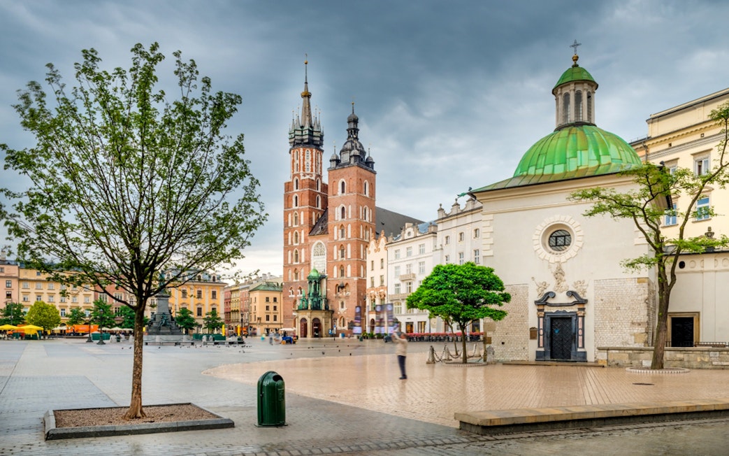 Saint Mary's Basilica in Krakow's Old Town square with surrounding historic buildings.