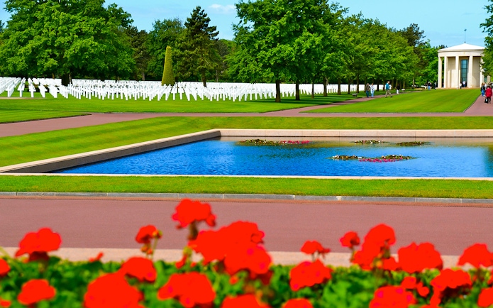 Normandy American Cemetery with rows of white crosses and reflecting pool.