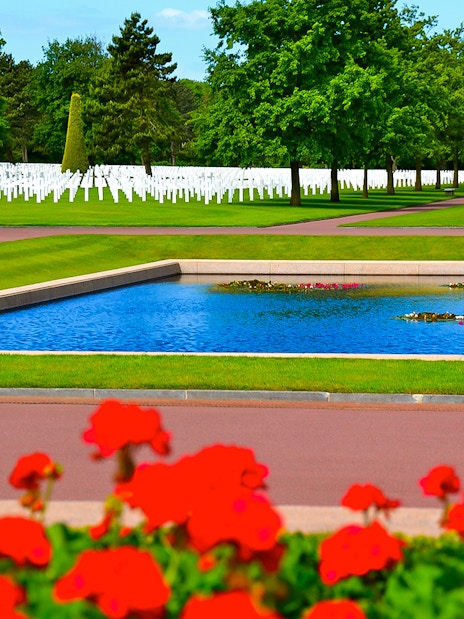 Normandy American Cemetery with rows of white crosses and reflecting pool.