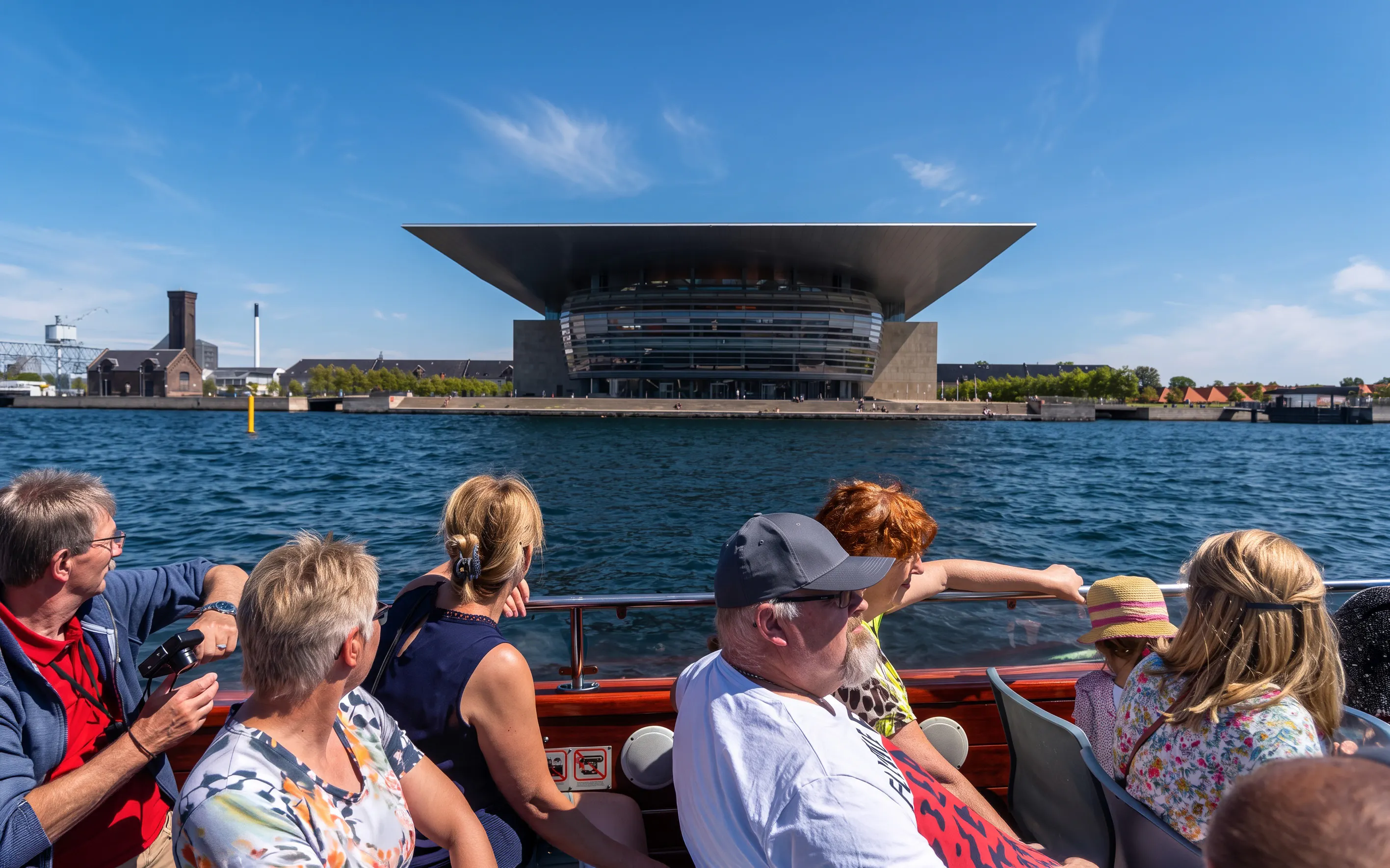 Tourists on a boat tour in Copenhagen viewing the Copenhagen Opera House.