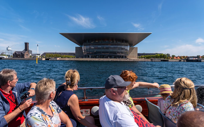 Tourists on a boat tour in Copenhagen viewing the Copenhagen Opera House.