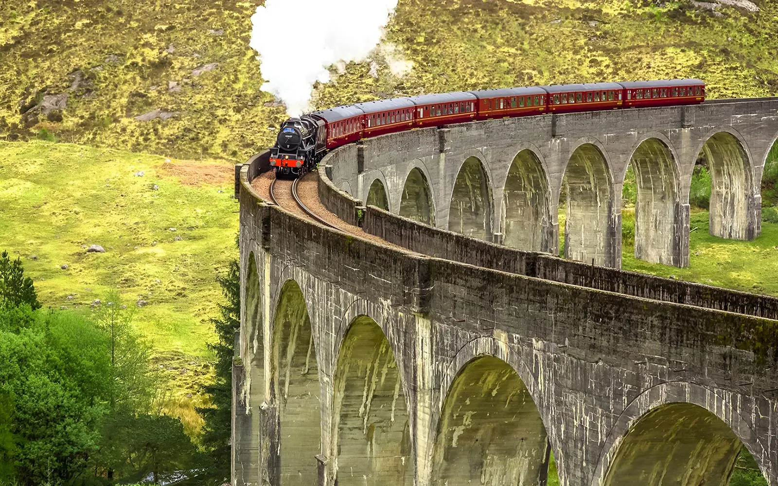 Jacobite Steam Train crossing Glenfinnan Viaduct in the Scottish Highlands.