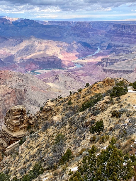 Grand Canyon South Rim overlook with visitors and expansive canyon view.