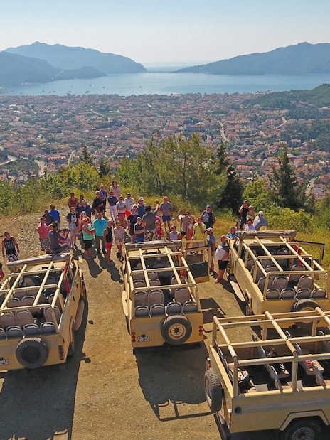 Group on Antalya hilltop with jeeps, overlooking city and sea during guided safari tour.