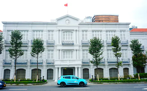 Historic colonial building with Vietnamese flag in Da Nang city tour.