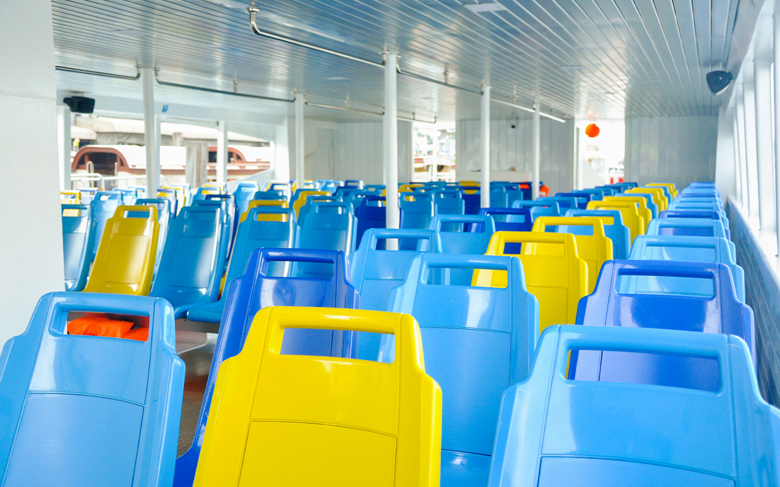 Colorful seats on Chao Phraya Tourist Boat for Bangkok hop-on-hop-off tour.
