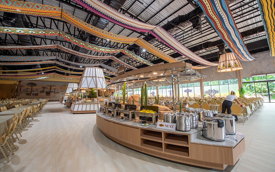 Buffet setup at Savanna restaurant in Safari World with colorful ceiling decor.