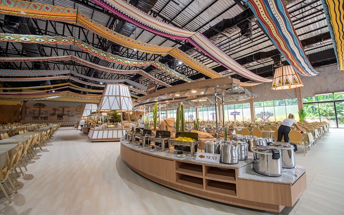 Buffet setup at Savanna restaurant in Safari World with colorful ceiling decor.