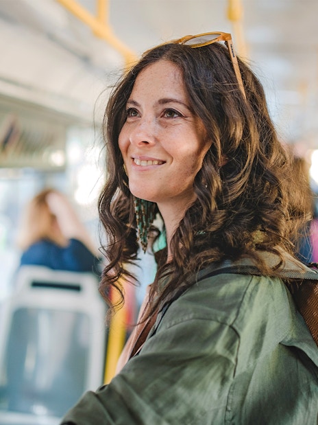 Traveller smiling on a bus, using public transport.