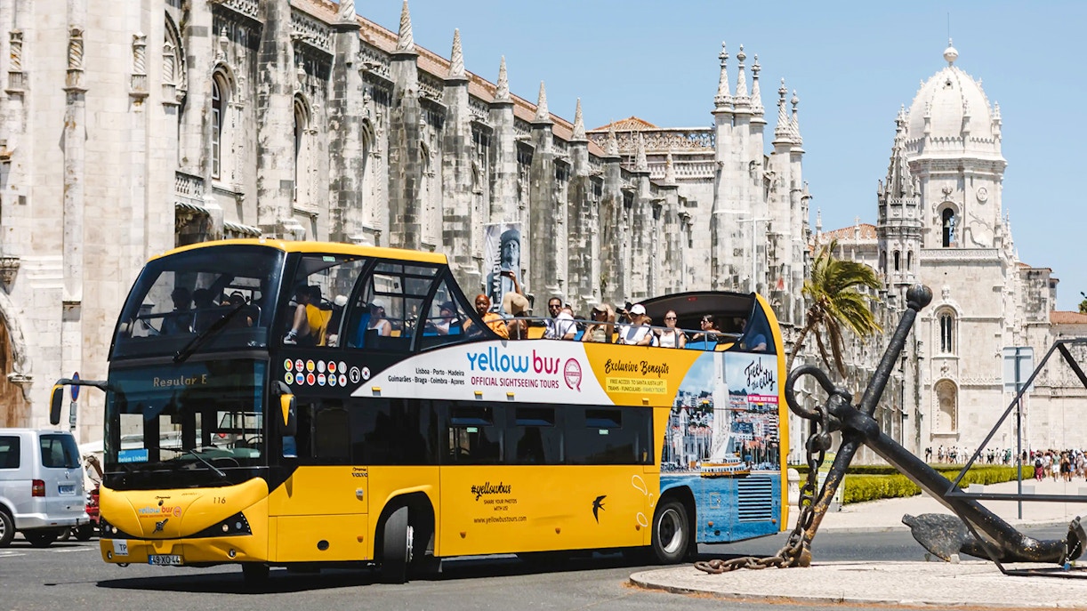 Tourists on a yellow sightseeing bus near Jerónimos Monastery, Lisbon.
