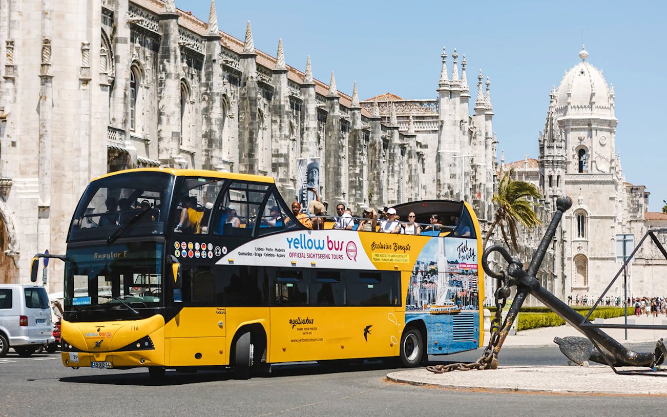 Tourists on a yellow sightseeing bus near Jerónimos Monastery, Lisbon.
