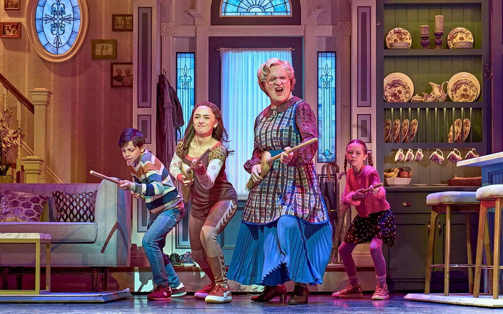 Family dancing in a kitchen scene from the Mrs. Doubtfire musical.