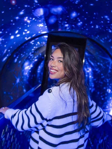 Person walking through a starry tunnel experience called The TUBE.