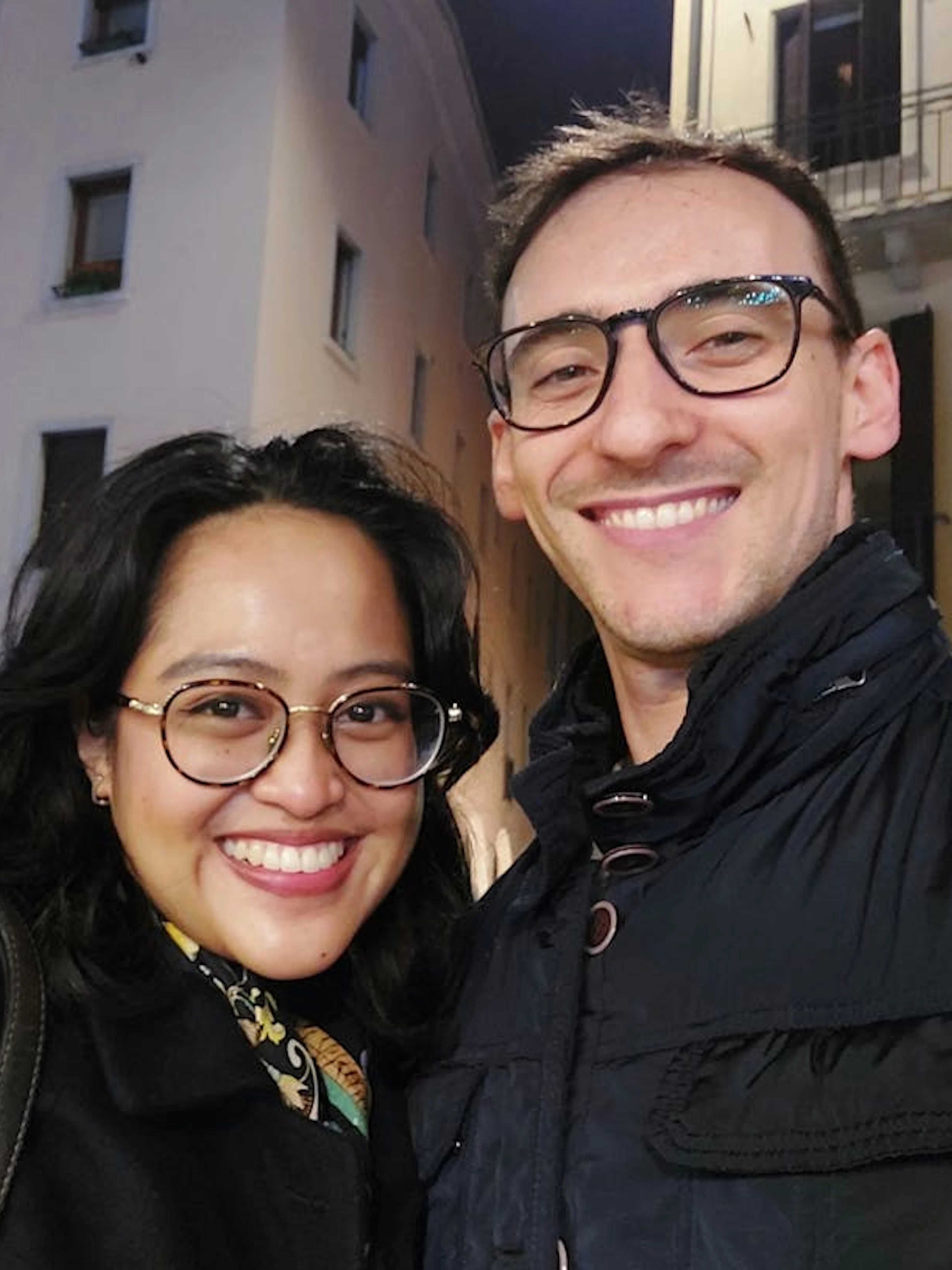 Couple smiling in front of historic building during Padua city exploration game.