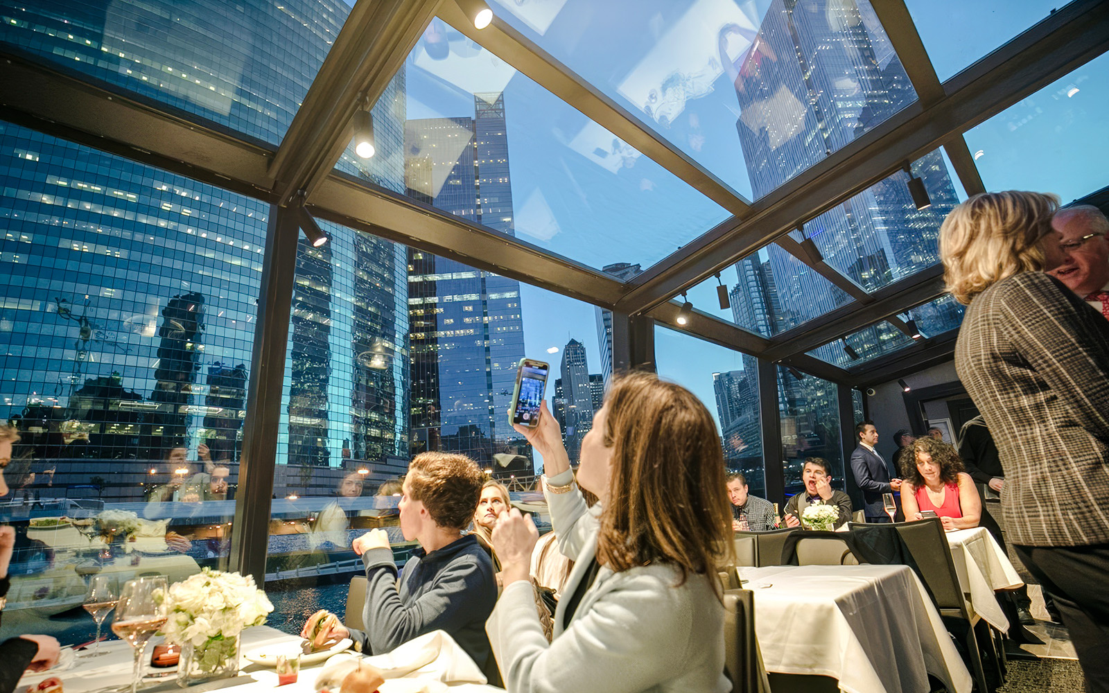Dinner cruise guests enjoying Chicago skyline views through glass windows.