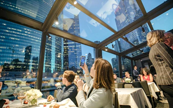 Dinner cruise guests enjoying Chicago skyline views through glass windows.